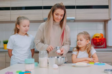 Annem kızlarına mutfakta hamur pişirmeyi öğretiyor.