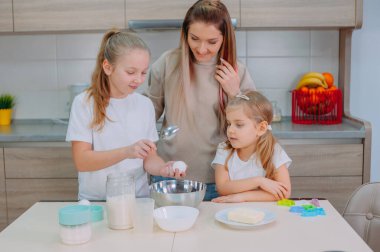 Annem kızlarına mutfakta hamur pişirmeyi öğretiyor.