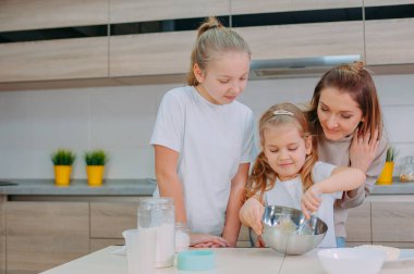 Annem kızlarına mutfakta hamur pişirmeyi öğretiyor.