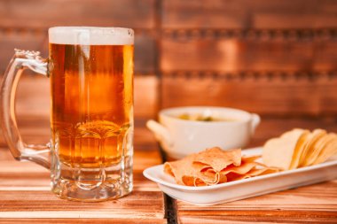 Bir bardak bira, patates kızartması ve sebze soslu abur cubur. Yeşil guacamole ile aperatif kupa ya da yarım litre bira. Kapat.,