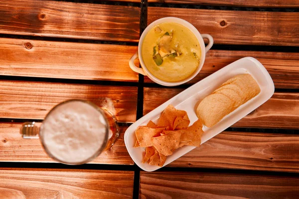 Bir bardak bira, patates kızartması ve sebze soslu abur cubur. Yeşil guacamole ile aperatif kupa ya da yarım litre bira. Kapat.,