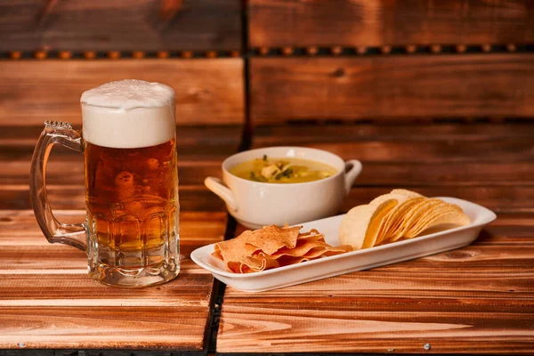 Bir bardak bira, patates kızartması ve sebze soslu abur cubur. Yeşil guacamole ile aperatif kupa ya da yarım litre bira. Kapat.,