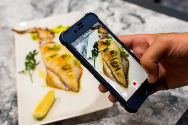 taşınabilir mürekkep balığıyla yemek fotoğrafı çekmek.