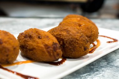 Tabakta sos olan kızarmış kroketler.