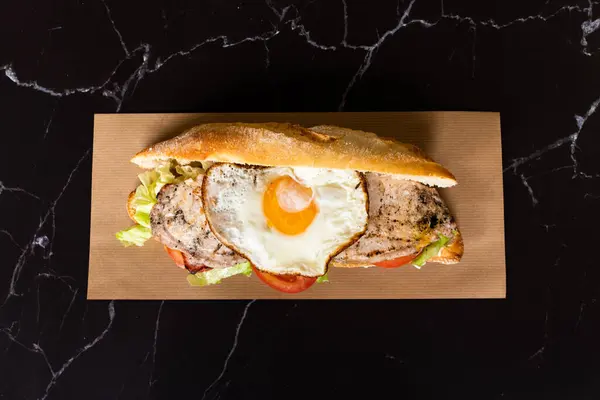 fried egg sandwich baguette with tomato and lettuce