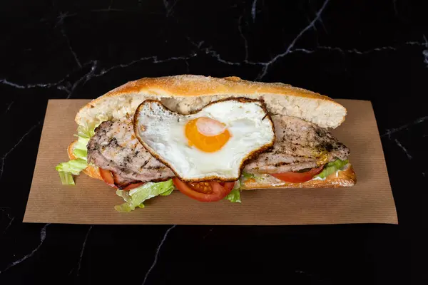 fried egg sandwich baguette with tomato and lettuce