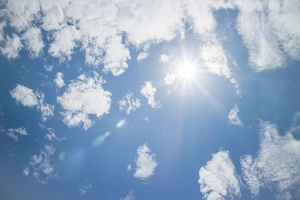 Синее небо с солнцем и облаками — стоковое фото