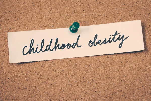 Nota obesidade infantil fixado no quadro de avisos — Fotografia de Stock