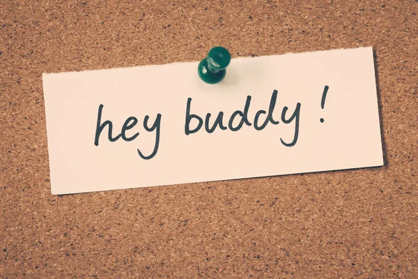 Hey buddy note pinned on the bulletin board — стоковое фото