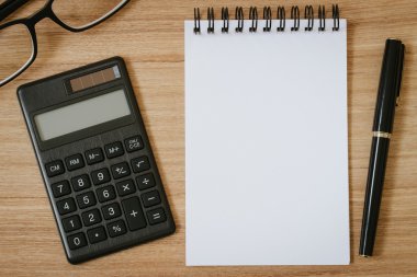 hesap makinesi, not defteri, kalem ve ahşap arka plan gözlük