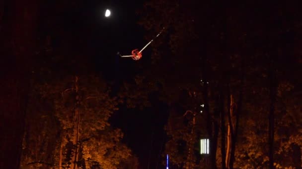 Video paseo en catapulta por la noche en el parque bajo la luna luminosa — Vídeos de Stock