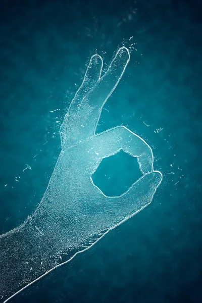 De illustratie hand geeft een symbool gemaakt van ijs op een turkooizen achtergrond Ok — Stockfoto