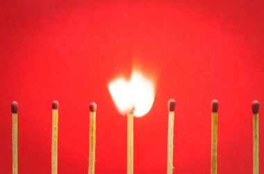 Burned match setting on red background for ideas and inspiration clipart