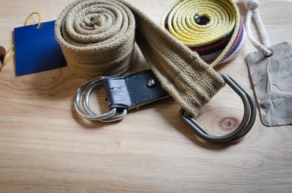 Set of fabric belt and label on wood background — Stock Photo, Image
