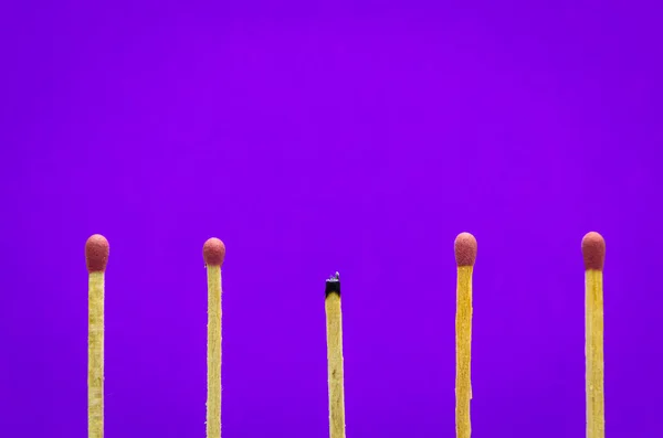 Сгоревшие спички на фиолетовом фоне для идей и вдохновения — стоковое фото