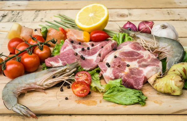 Свежее мясо, морепродукты и овощи на борту кухни — стоковое фото