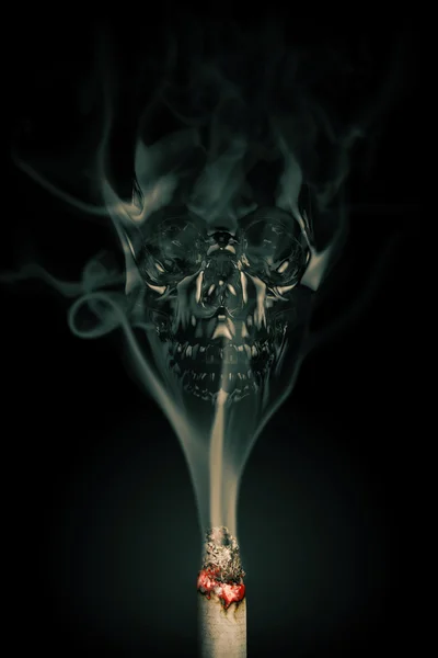 Kouř ve tvaru lebky vychází z cigarety na černém — Stock fotografie