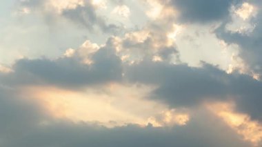 Dramatik güneş ışığı beyaz bulutları delip geçer güzel mavi bir yaz gökyüzünde doğal bir bulut manzarası yaratır.