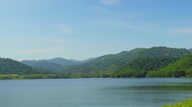 Bereketli yeşil dağları ve mavi gökyüzü olan bir su deposu..