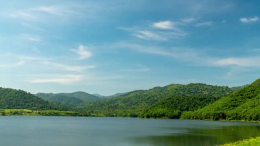 Zaman ayarlı. Bereketli yeşil dağları ve mavi gökyüzü olan bir su deposu..
