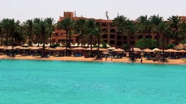 Güneşli yaz gününde Mısır 'ın başkenti Hurghada' da, Kızıl Deniz 'de insanlarla dolu bir deniz manzarası..