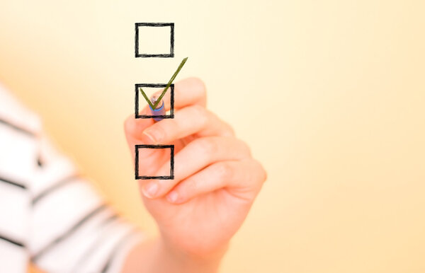 Hand putting check mark with pen