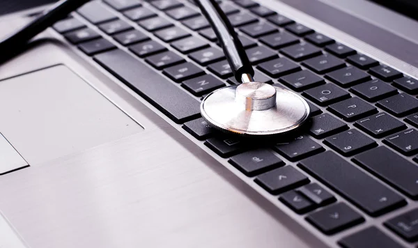 Stethoscope resting on a computer keyboard - concept for online medicine or IT support — Stock Photo, Image