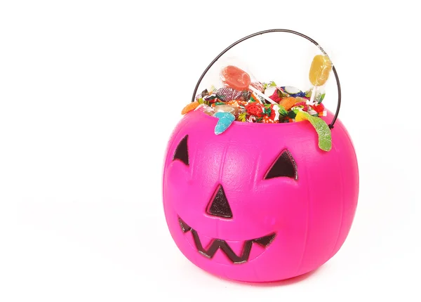 Pink plastic pumpkin filled with candy — Stock Photo, Image