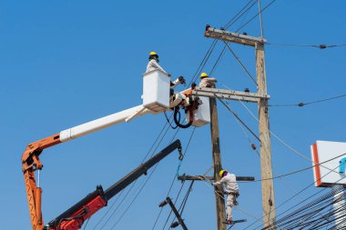 Elektrikçiler yüksek gerilim sistemine ekipman yüklüyorlar.