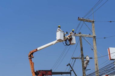 Elektrikçiler yüksek gerilim sistemine ekipman yüklüyorlar.