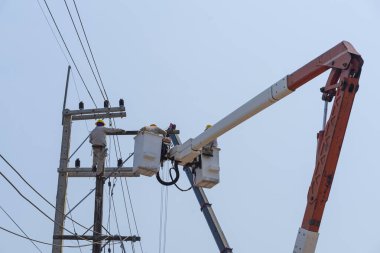 Elektrikçiler yüksek gerilim sistemine ekipman yüklüyorlar.