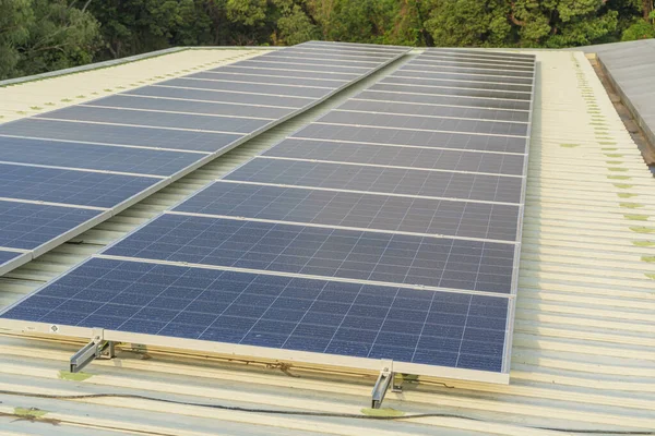 大きな建物の屋根に設置された太陽電池パネルには汚れやほこりがたくさんあります ストックフォト