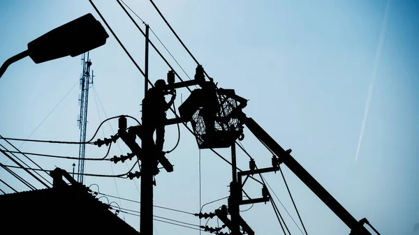 Siluet Işçileri Elektrik Teçhizatını Elektrik Direklerine Kuruyorlar Telifsiz Stok Fotoğraflar