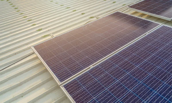 大きな建物の屋根に設置された太陽電池パネルには汚れやほこりがたくさんあります ロイヤリティフリーのストック画像