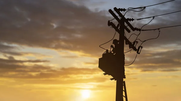 Silhouette technicians work on high voltage transformers.