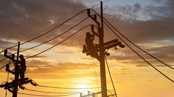 Silüet Elektrikçiler Yeni Kablo Ekipman Yüklemek Için Yüksek Voltaj Kuleleri Stok Resim