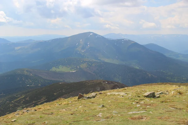 Rotsen en bergtoppen onder bewolkte hemel — Stockfoto