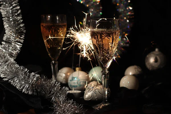 İki bardak şampanya, maytap ve noel süsü. Tatil atmosferi. Bokeh. Odak arkaplanı dışında. Mutlu Noeller ve mutlu yıllar.!