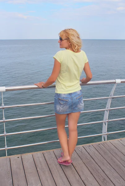 Csinos hölgy marad nekünk a tengerre néző fél fordulattal — Stock Fotó