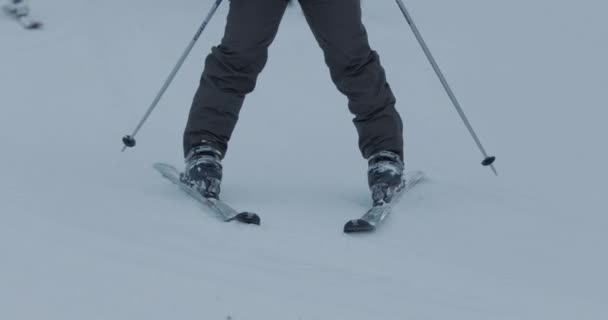 Eine Person fährt mit Skiern einen schneebedeckten Hang hinunter — Stockvideo