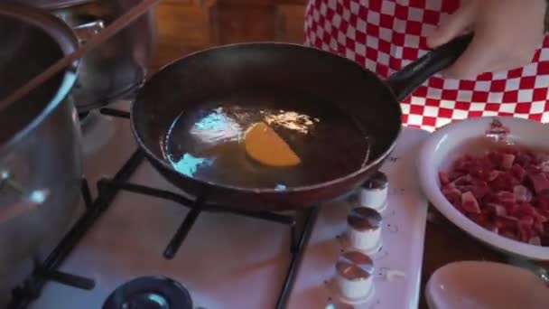 Kucharze nalewają grzyby do gorącej patelni. Jedzenie na kuchni. — Wideo stockowe