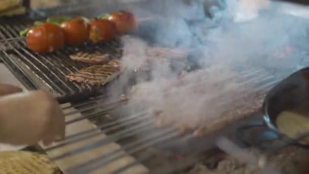Cocina tradicional turca cocinada en la parrilla Adana Kebab. Chef cocinando carne en la parrilla de barbacoa para los clientes. Shish tradicional turco kebab y verduras en la barbacoa fuego. — Vídeos de Stock