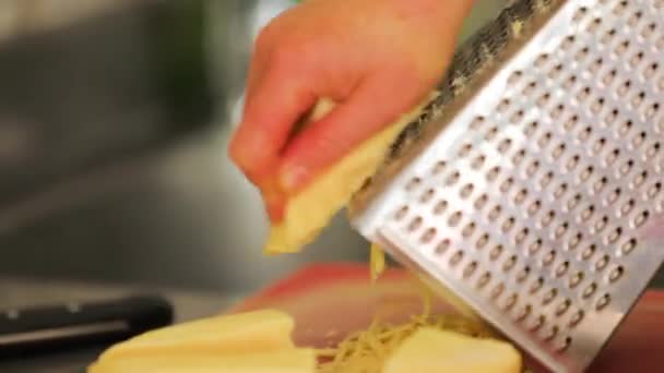 Chef rallando queso cheddar para cocinar. — Vídeos de Stock