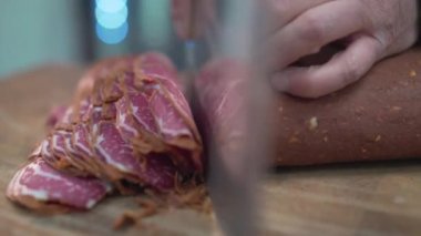 Bir aşçı Türk pastırmasını dilimliyor.
