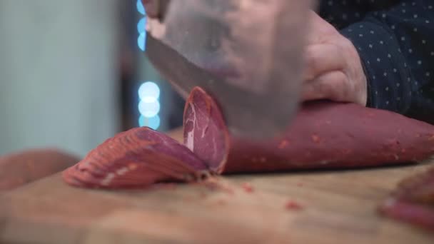 En kockar som skär turkisk bacon. — Stockvideo