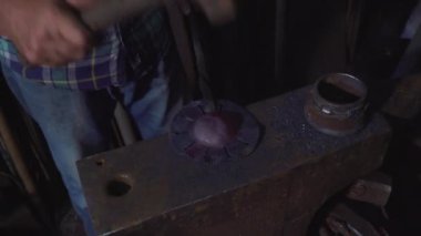 Demirci malı çekiçle dövüyor.