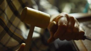 Geleneksel zanaatkârın yakından görünüşü çekiçle odun kesmektir.