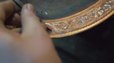 Bir zanaatkar Gaziantep Çarşısı 'nda bakır bir tencere oyuyor.