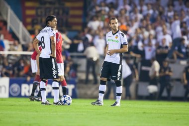 Alejandro Dominguez (L) ve Roberto Soldado (R) bir top ile