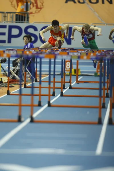 Дунпэн Ши из Китая соревнуются в беге на 60 метров с барьерами — стоковое фото